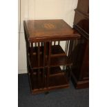 An inlaid walnut revolving bookcase with floral motif centre, two tiers with slatted sides (one