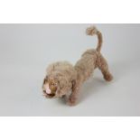 A small wire framed lion soft toy, with painted pottery face, 13cm long (a/f)