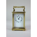 A gilt brass and bevelled glass cased carriage clock, the rectangular white dial with Roman numerals