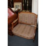 A Louis XVI style boudoir chair with carved frame, upholstered back and seat, with open padded arms,