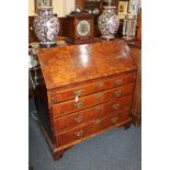 A George III walnut bureau with cross banding and herringbone inlay, the fall enclosing an