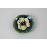 A Moorcroft pottery small circular dish, in the yellow pansy pattern on green ground 8cm diameter