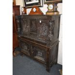 A 17th century and later carved oak cupboard, the top section with two cupboards, central panel