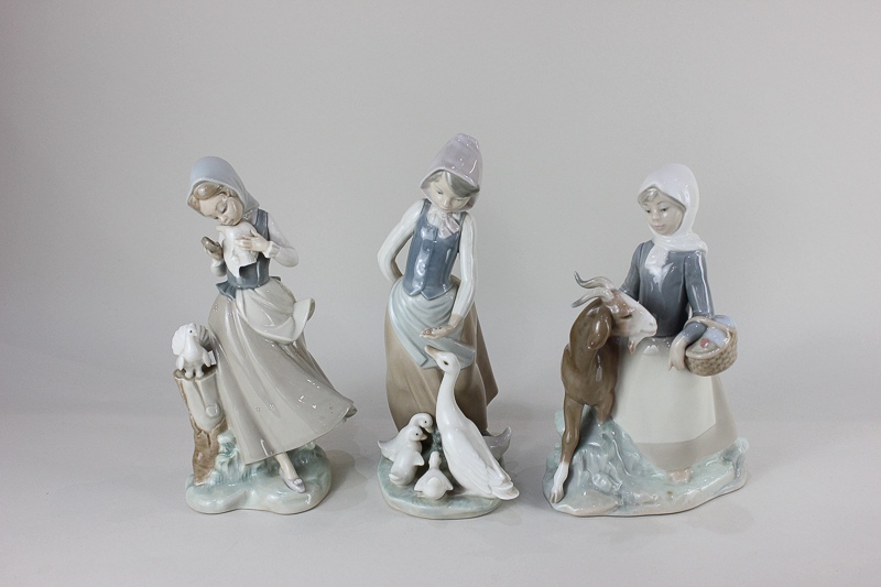 Three Lladro porcelain figures of girls with animals, one feeding a goose and goslings, one with a