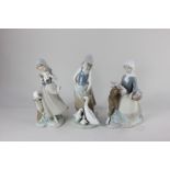 Three Lladro porcelain figures of girls with animals, one feeding a goose and goslings, one with a