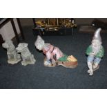 Two composite garden ornaments of dogs, together with two painted garden gnomes