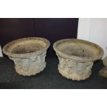 A pair of stone composition garden urn planters cast with masks and foliage (lack bases), 50cm