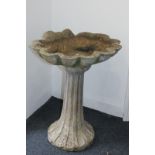 A stone composition garden bird bath with scallop shell shaped bowl, on flared base, 54cm