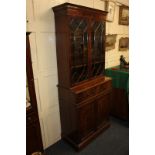 A reproduction mahogany bookcase, with two glazed panel doors enclosing two shelves, the base