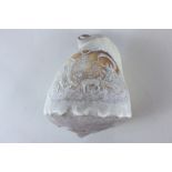 A carved conch shell with scene of a couple in a chariot led by lions and a figure playing pipes,