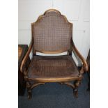 A bergiere arm chair with cane seat and arched back, scroll carved open arms on baluster supports