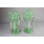 A pair of green glass lustres, each with frilled rim and cut glass drops, 30cm high