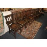 A set of eight chapel chairs, slatted back s with prayer book holders, solid elm seats, on tapered