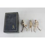 Three silver plated figures of men in 19th century dress with top hat, tails, cane and whip,