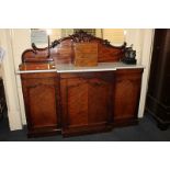A fruitwood and mahogany break front sideboard with white marble top, central drawer above three