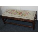 An oak framed long footstool with tapestry upholstered drop-in seat (a/f), 91cm