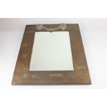 An early 20th century hammered copper and bevelled glass wall mirror, with applied brass rams head