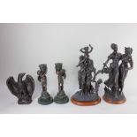 A pair of bronzed resin figural candlesticks modelled as winged cherubs, two similar figure groups