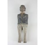 A carved and painted wooden doll of a bearded man wearing a hat, missing arms (a/f) 35cm