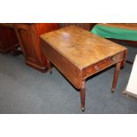 A mahogany Pembroke table with two drop flaps and drawers each end, on four reeded legs with
