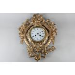 A Continental gilt metal wall clock, the circular enamel dial with Roman numerals, striking on a