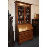 An Edwardian inlaid mahogany bureau bookcase with panel glazed doors enclosing three shelves above