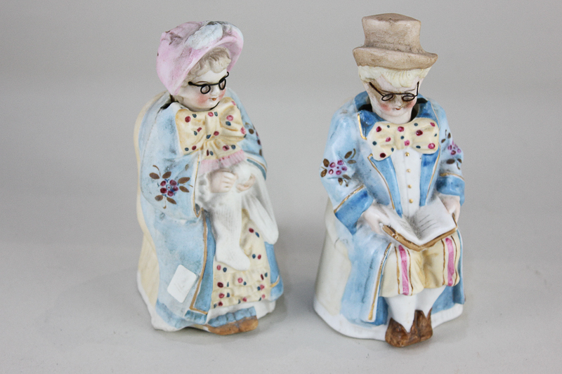 A pair of bisque nodding figures of a lady and gentleman, both wearing wire framed glasses, 14cm