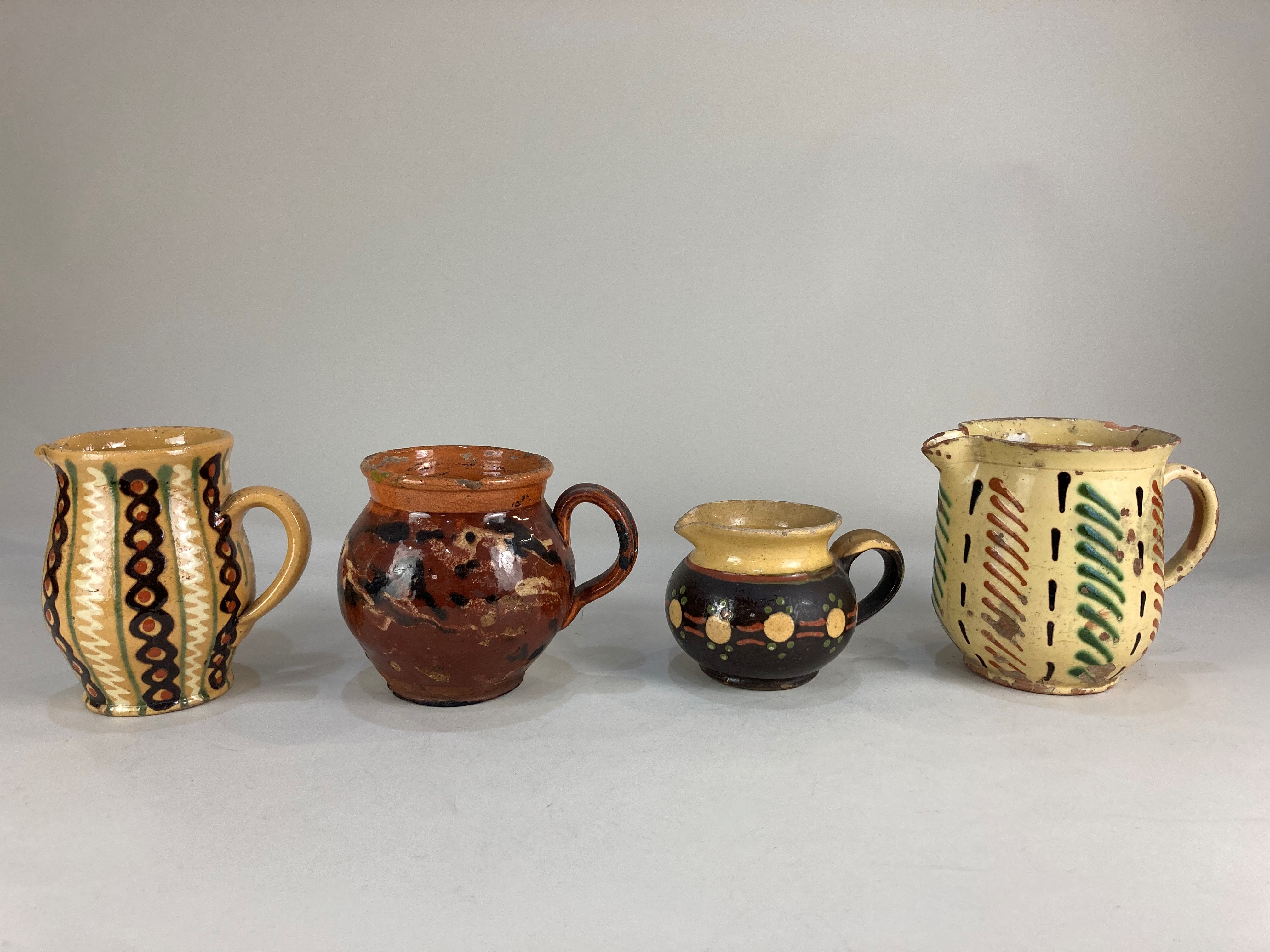 Four French Faience pottery jugs, in various patterns & sizes, tallest 14cm high