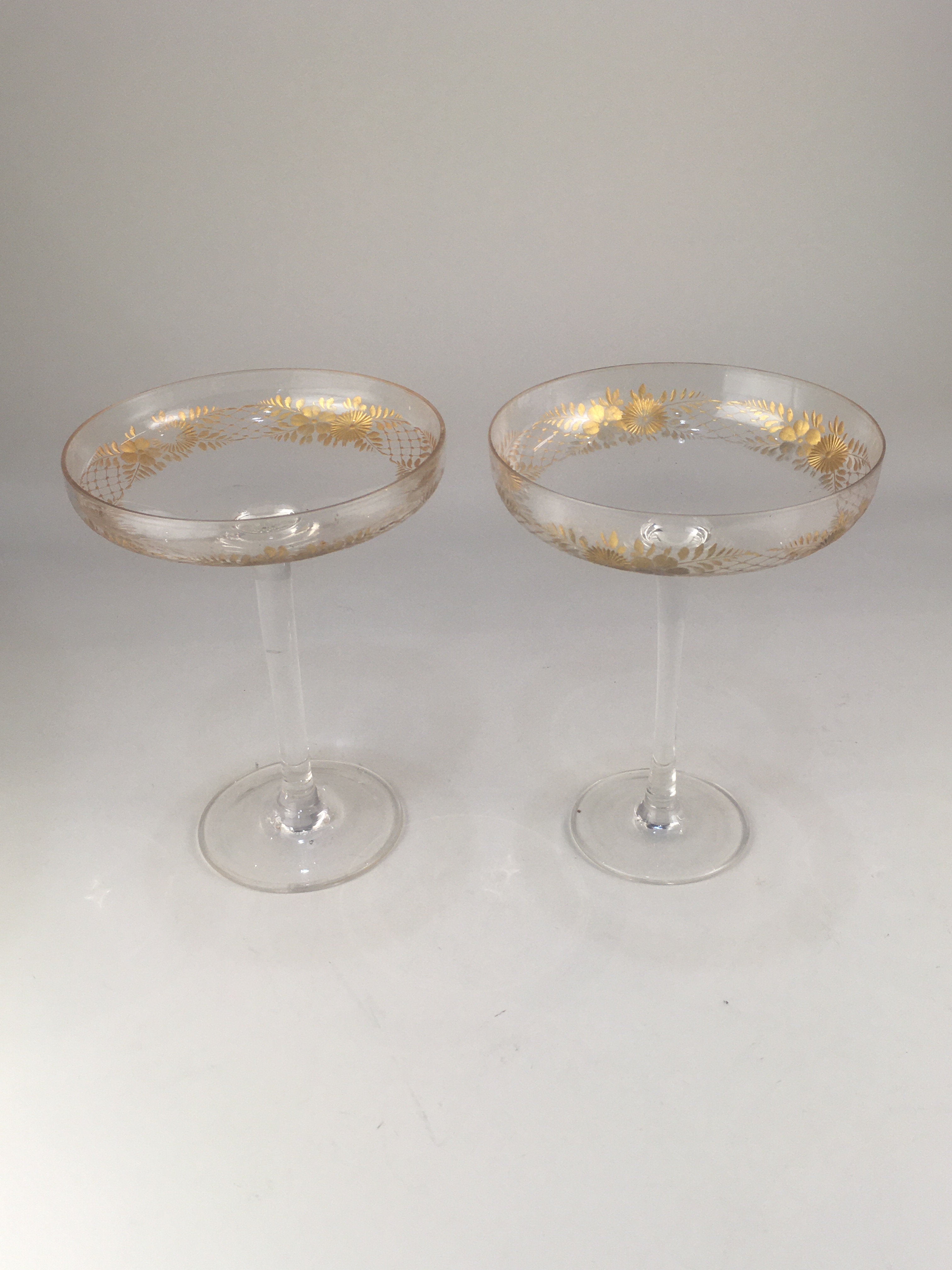 A near pair of glass bonbon dishes, each with shallow circular bowl on tall stem and circular