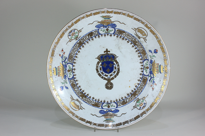 A porcelain charger, decorated with armorial central crest, polychrome and gilt decoration, 45.5cm