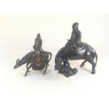 A bronzed metal model of a figure seated atop a buffalo, 28cm high, and another of a (matched)