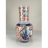 A Japanese Imari porcelain vase, with cylinder neck, decorated with panels of blossom and flowers,