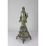 A Japanese brass figure of a sage holding a gourd, standing atop rocks, on integral stand, raised on
