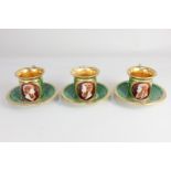 Three porcelain green and gilt coffee cups, each painted with oval cameos of classical figures
