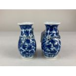 A pair of Chinese porcelain small blue and white vases, of baluster form, each with applied dragon