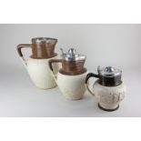 Three stoneware ale jugs, makers Turner and Adams, comprising two silver mounted with hinged lids,