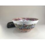 A large porcelain punch bowl, decorated with a continuous scene depicting foreign merchants in
