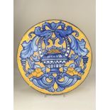 A Continental maiolica style wall plate, decorated with fruit filled cornucopia and vase, in