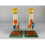 A pair of Clarice Cliff Bizarre 'Crocus' pattern candlesticks, each with tapered faceted stem on