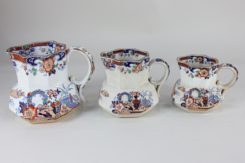 A graduated set of three Victorian pottery jugs, decorated in the Japanese style, each stamped '