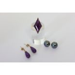 An amethyst dress ring in 9ct gold; a pair of black pearl ear studs on 9ct gold fittings; a pair