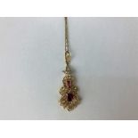 A ruby and diamond pendant set with a pear cut ruby and graduated rose cut diamonds