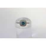 A zircon cluster ring with a central blue stone within a two row white stone border