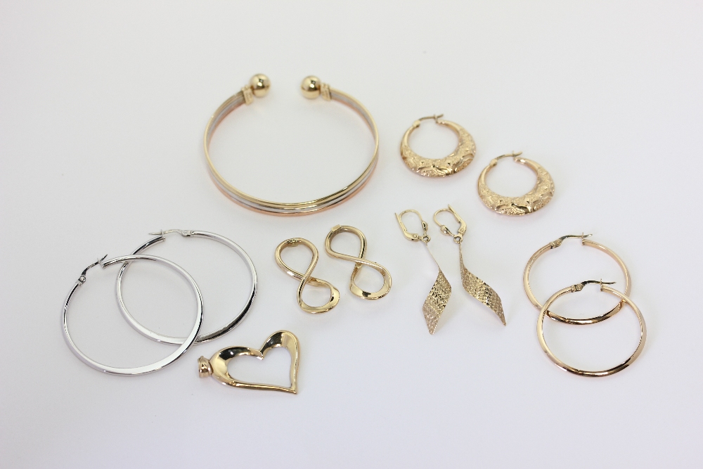 A 9ct three colour gold open end bangle, a pair of 9ct white gold hoop earrings, four pairs of 9ct