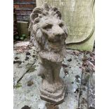 A composition stone garden statue of a seated lion, 57cm high
