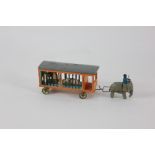 A small wooden toy animal cage carriage led by an elephant with rider, with four carved animals