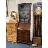 A narrow mahogany bureau bookcase, with glazed panel door enclosing three shelves, fall front over