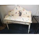 A white painted nursery bench seat, with raised back and drawer, decorated with a seated monkey,