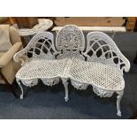 A white painted cast iron three seat garden bench with scrolling pierced back and seat on cabriole
