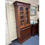 A Victorian mahogany bookcase, with two glazed panel doors enclosing three shelves, above two